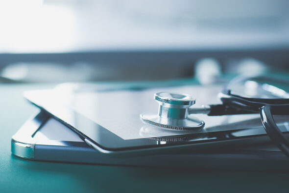 臨床試験をイメージさせる、聴診器が置かれた臨床研究資料