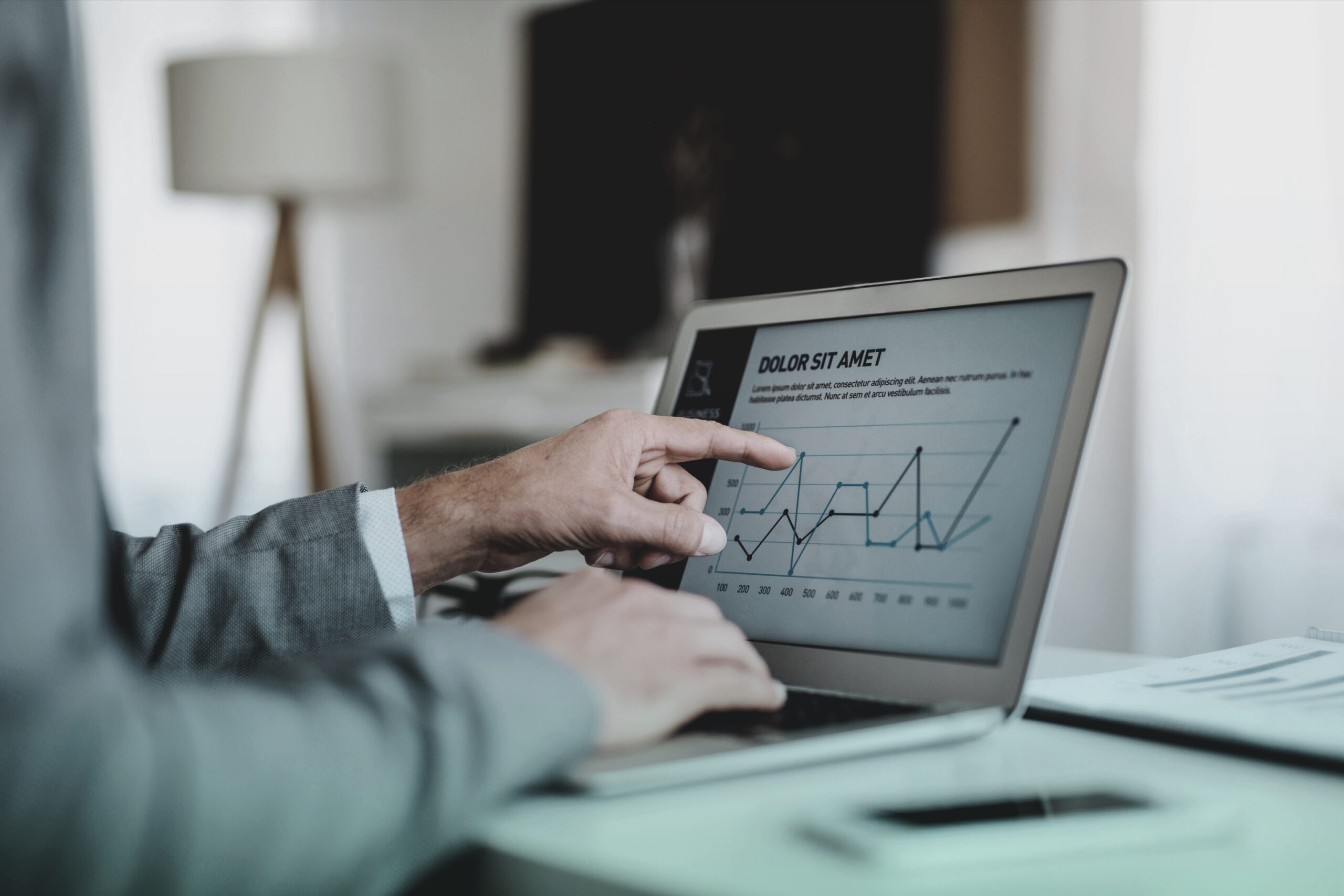 Hand pointing to data charts on a laptop screen, illustrating AI-powered localization technology